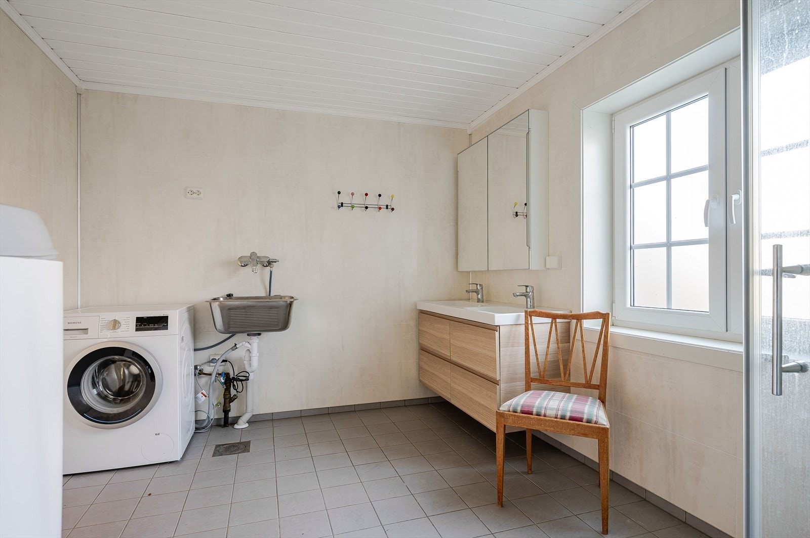 I hjørnet er det plass og opplegg for vaskemaskin og tørketrommel over om ønskelig, samt en vegggengt utslagskum. Baderommet har flislagt gulv med elektriske varmekabler, baderomsplater på veggene og elektrisk styrt vifte. Galleribilde