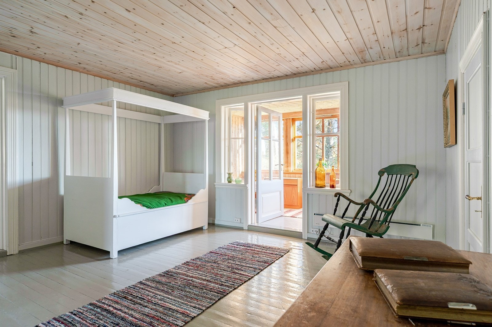 Stue i 2. etasje med malte tregulv og lysmalt panel på veggene. Galleribilde