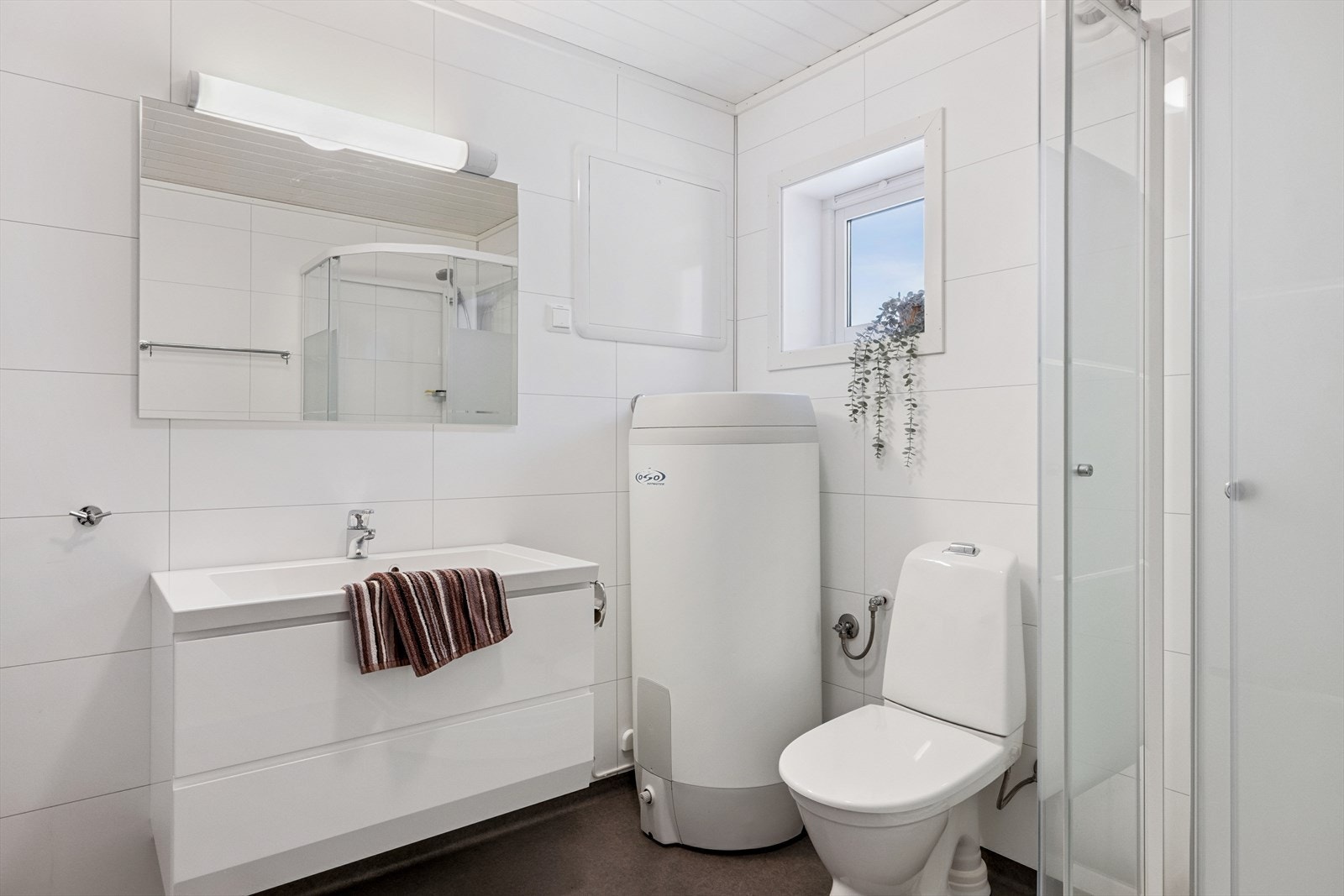 Bad med dusjkabinett og varmekabler i gulv. Opplegg for vaskemaskin. Galleribilde