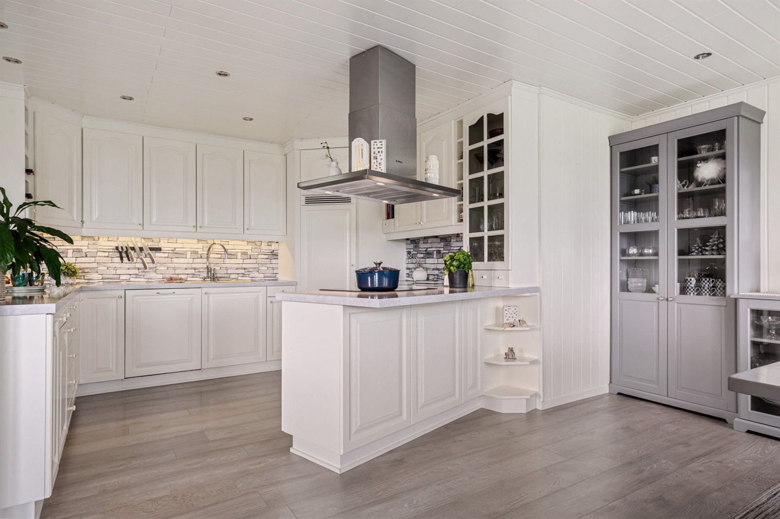 Pent kjøkken med lyse slette flater og flott benkeplate. Galleribilde