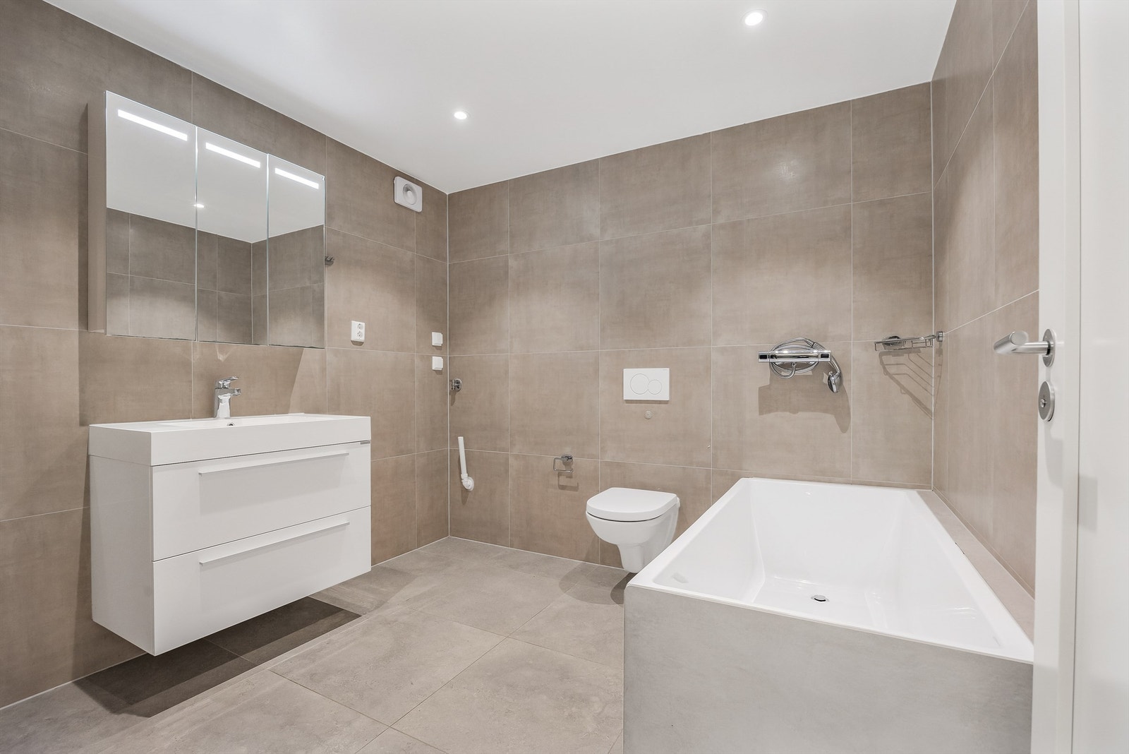 Fra kjøkkenet er det adkomst til et bad som i følge eier ble pusset opp i 2022. Badet fremstår pent med et moderne preg med flislagte gulv og vegger med varme i gulv. Galleribilde