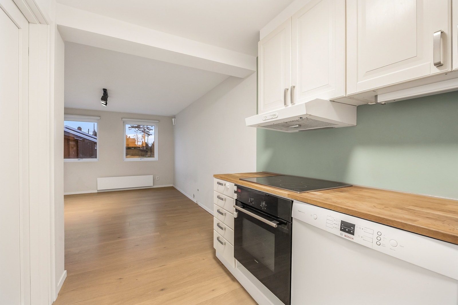 Kjøkkeninnredningen består av glatte fronter med fliser på vegg over benkeskap. Galleribilde