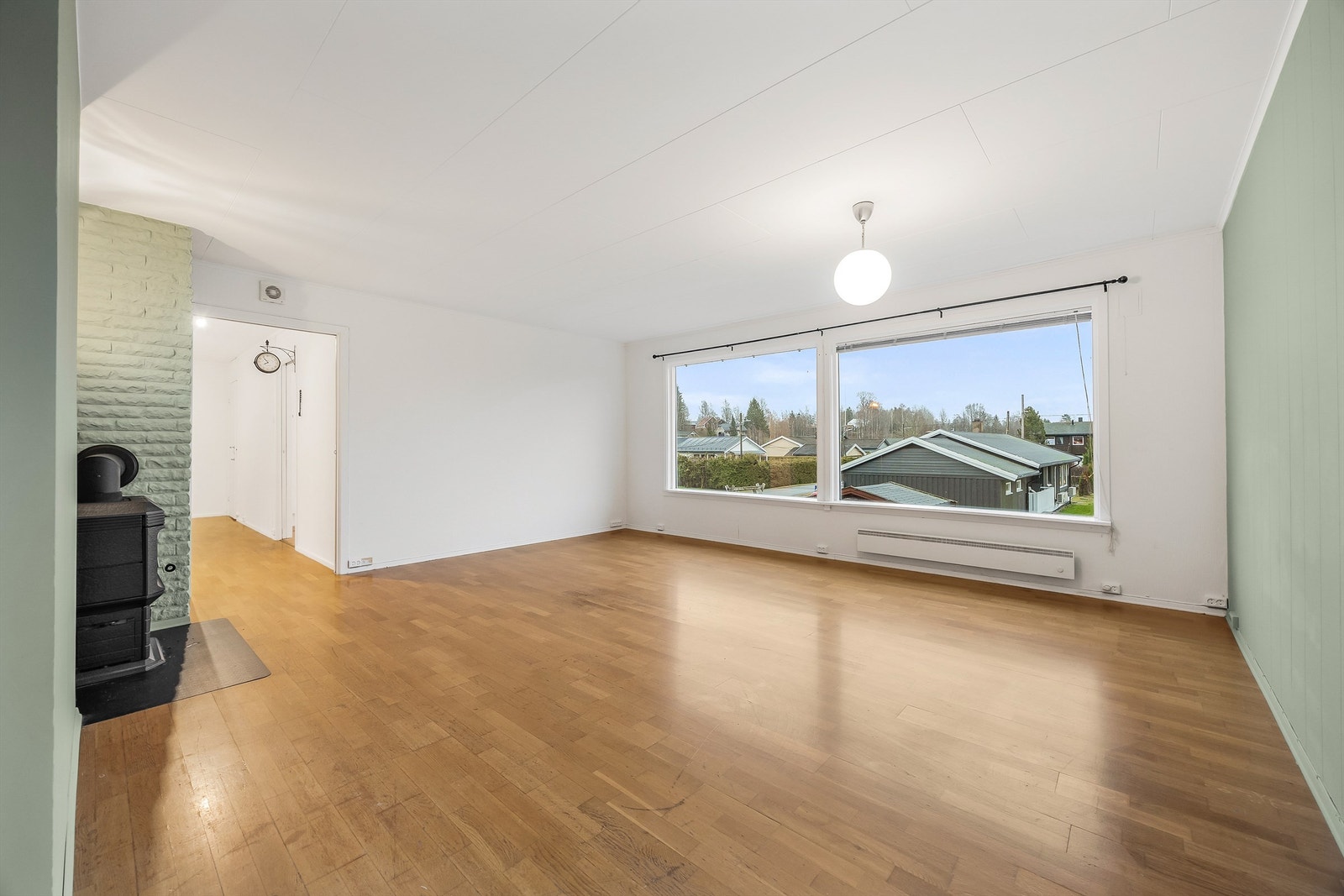 Stor og lys stue med store vinduer som fyller rommet med naturlig lys og skaper en åpen og luftig følelse i stuen. Galleribilde