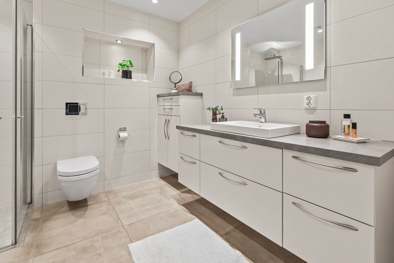 Flislagt bad/wc med vegghengt toalett og svært innholdsrik innredning fra Sigdal Galleribilde