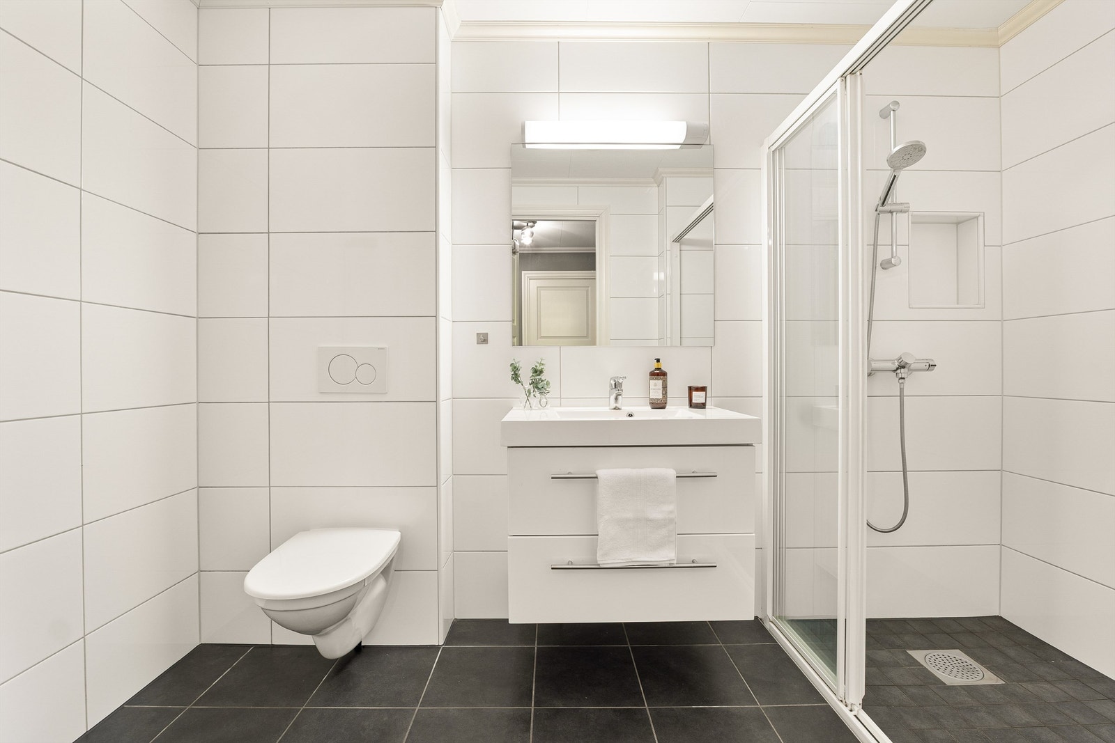 Pent og helfliset bad i 1. etasje med gulvvarme. Stor dusjnisje med skyvedør. Galleribilde