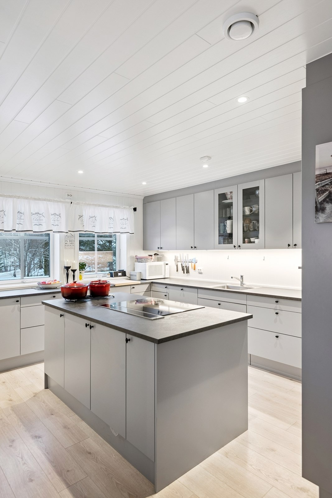 En praktisk kjøkkenøy med integrert platetopp og avtrekk gir ekstra arbeids- og lagringsplass. Galleribilde