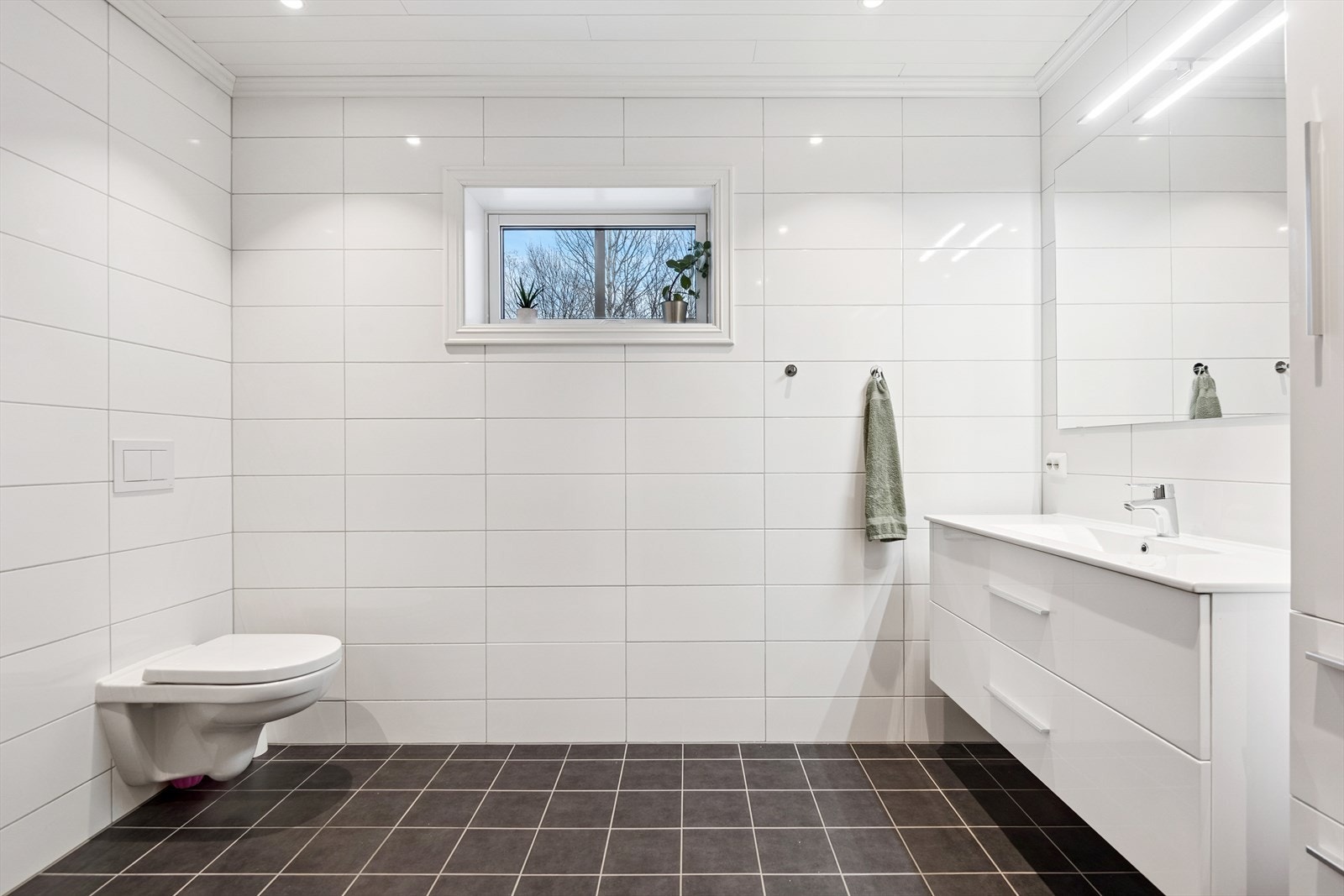 Badet i andre etasje er elegant utført med flislagte overflater og vegghengt toalett. Galleribilde