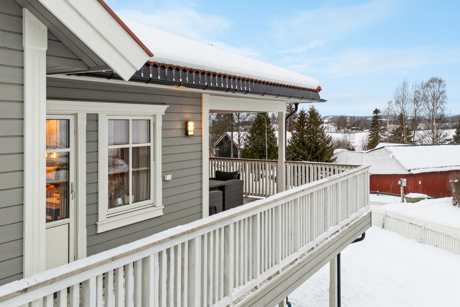 Terrassen har rekkverk og håndlist av treverk, som komplementerer husets stil. Galleribilde