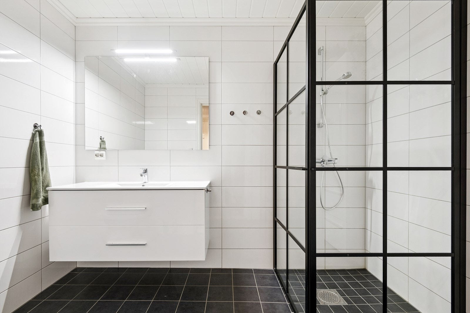 Badet i første etasje er helfliset og har en moderne dusjløsning med vegghengt armatur. Galleribilde