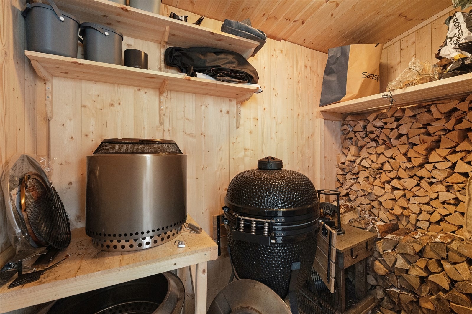 Bod med utvendig adkomst fra veranda for vedoppbevaring og praktisk lagringsplass for utendørsaktiviteter. Galleribilde