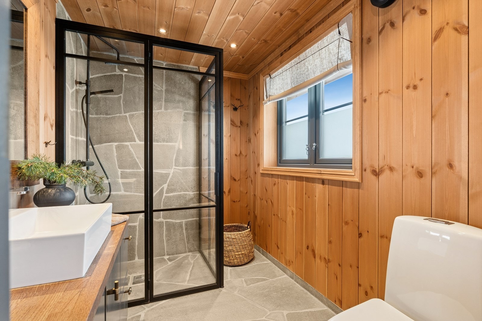 Dusjhjørne med glassvegger og elektrisk avtrekksvifte sikrer god ventilasjon på badet. Galleribilde