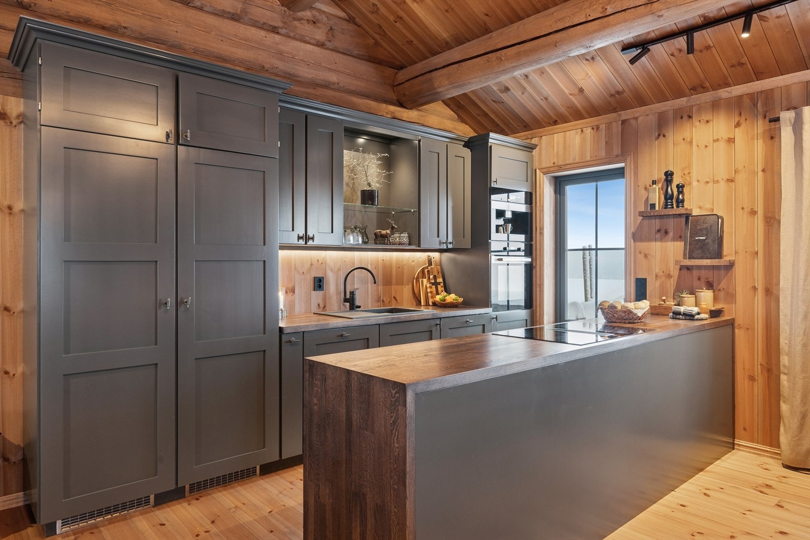 Hytten har et stort og romslig kjøkken fra 2021 med en solid heltre innredning med malte overflater og benkeplate i eik. Galleribilde