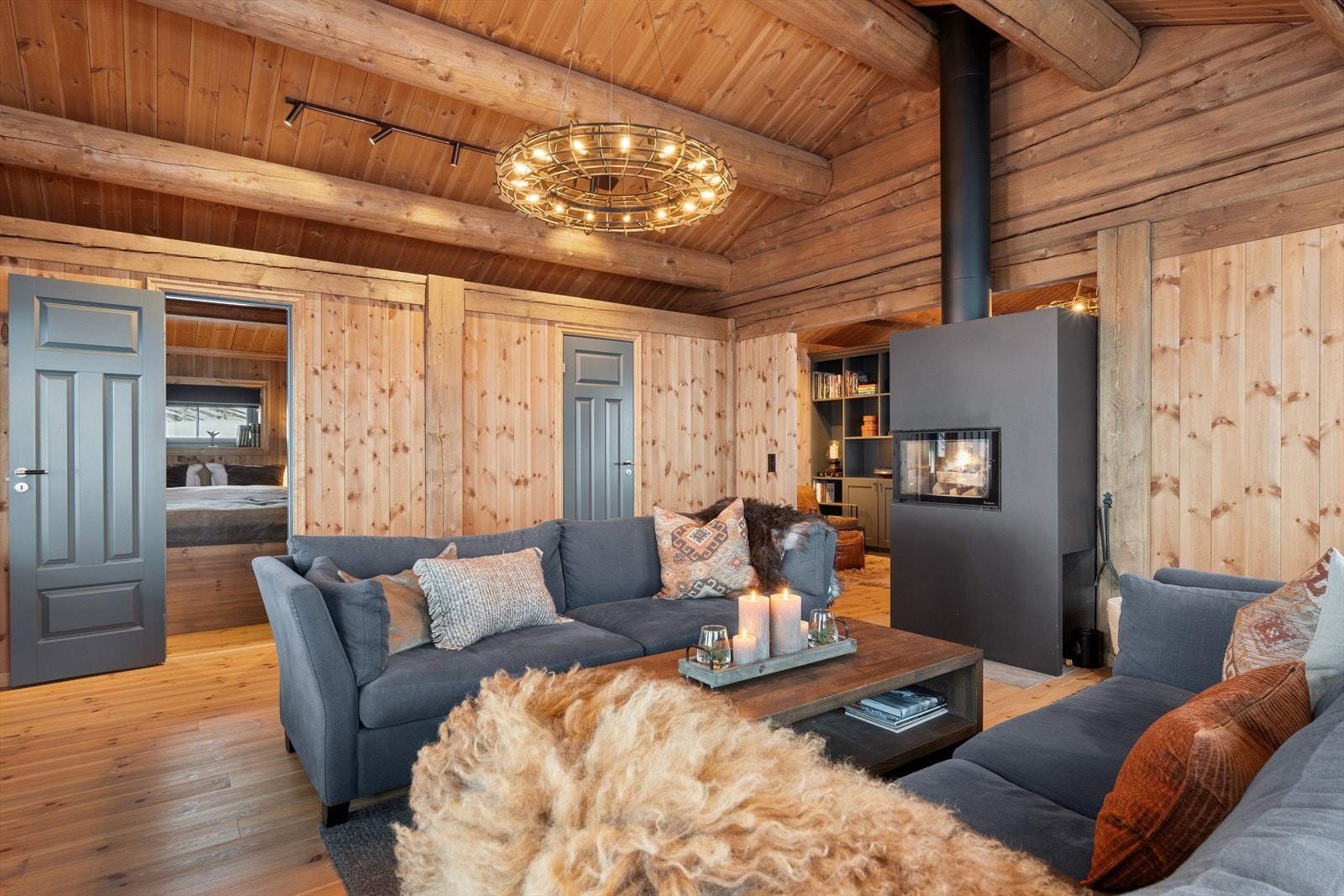 Stilig og energieffektiv peisovn fra Nordpeis med glassfelt på tre sider plassert i åpning mellom stue og kjøkken sørger for ekstra god temperatur og knitrende hygge på kalde vinterkvelder. Galleribilde