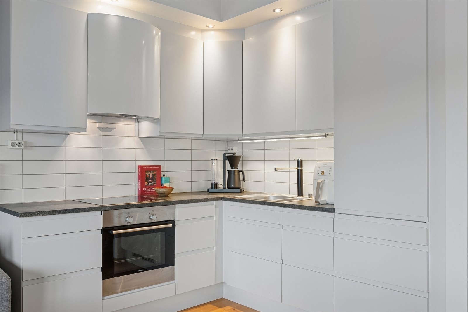 Lekkert og moderne vinkelkjøkken med rikelig oppbevaringsplass. Galleribilde