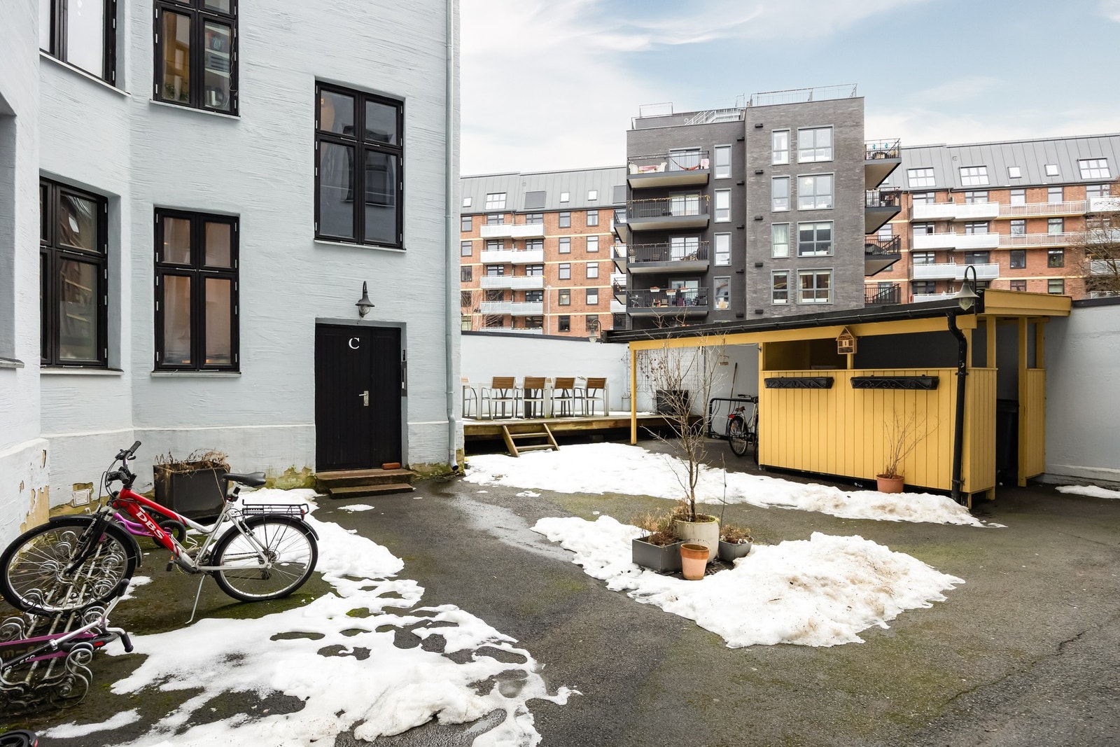 Pent opparbeidet bakgård med platting, bord og stoler. Galleribilde