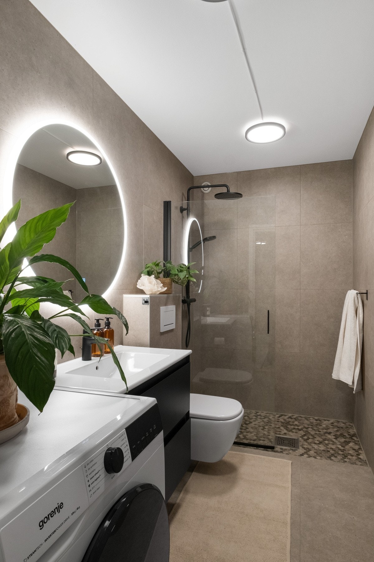 Det delikate baderommet er innredet med servant, vegghengt toalett, dusjhjørne med glassvegger, samt opplegg til vaskemaskin. Galleribilde