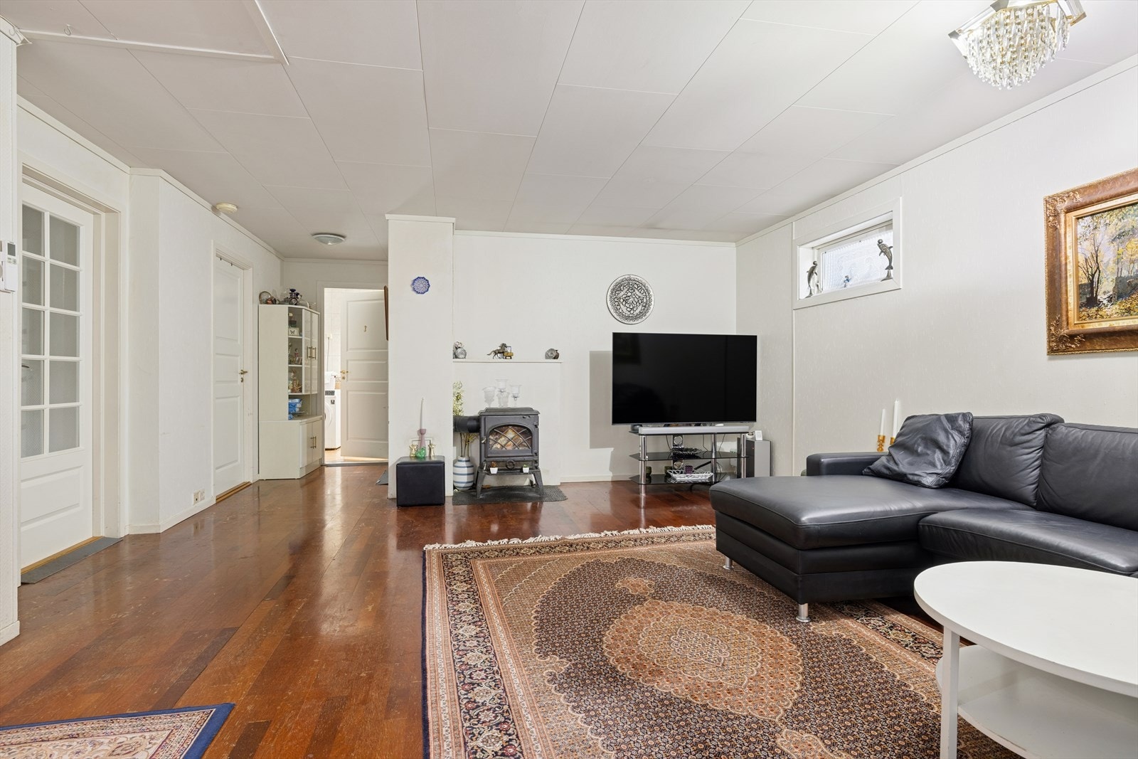 Stuen har oppvarming fra vedovn, varmepumpe og varmekabler Galleribilde