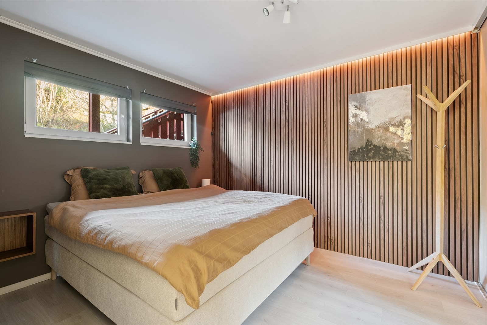 Hovedsoverommet har laminat på gulvet og en stilig spilevegg med belysning. Galleribilde