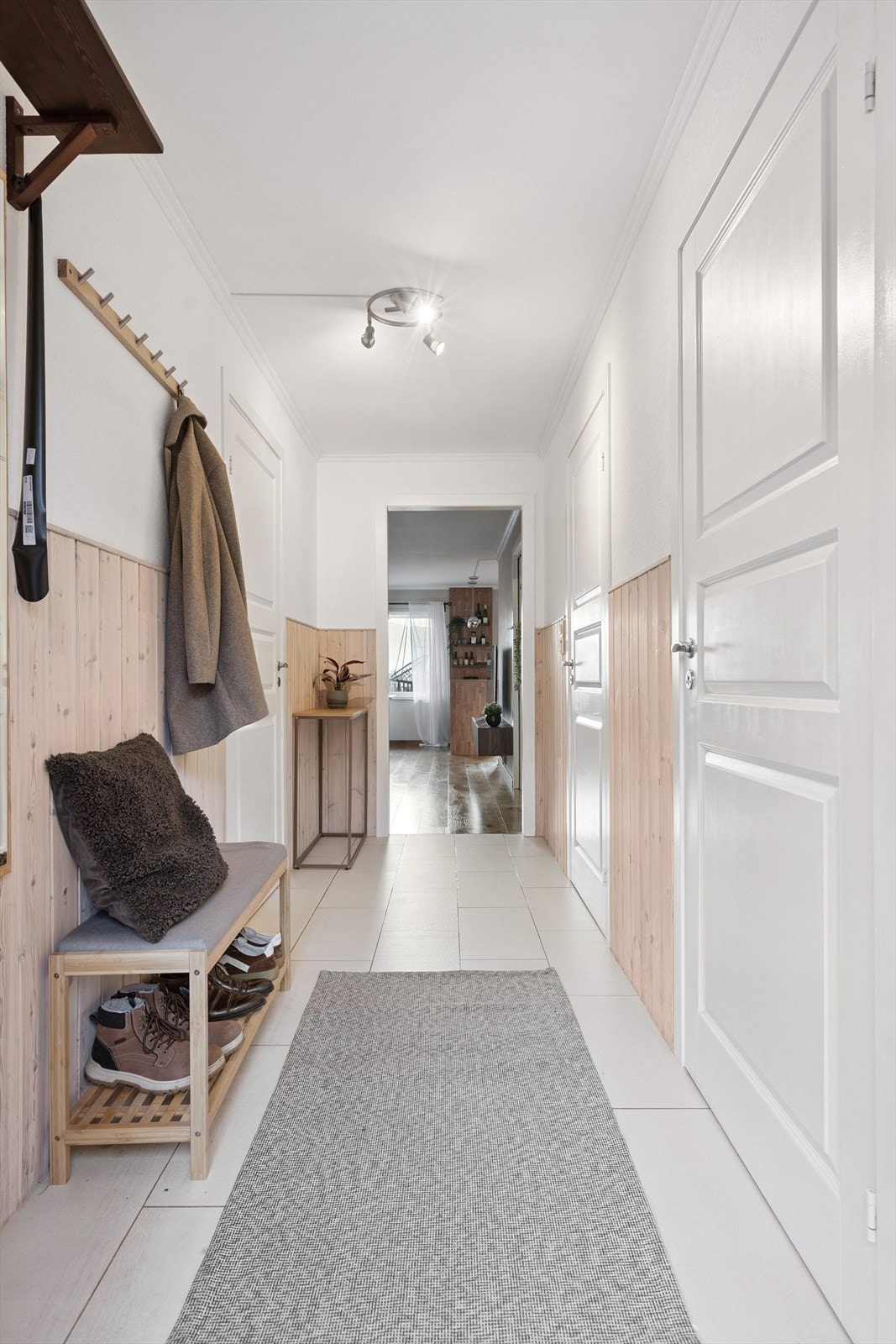 Gangen har panel på veggene og gir adkomst til alle rom i leiligheten. Galleribilde
