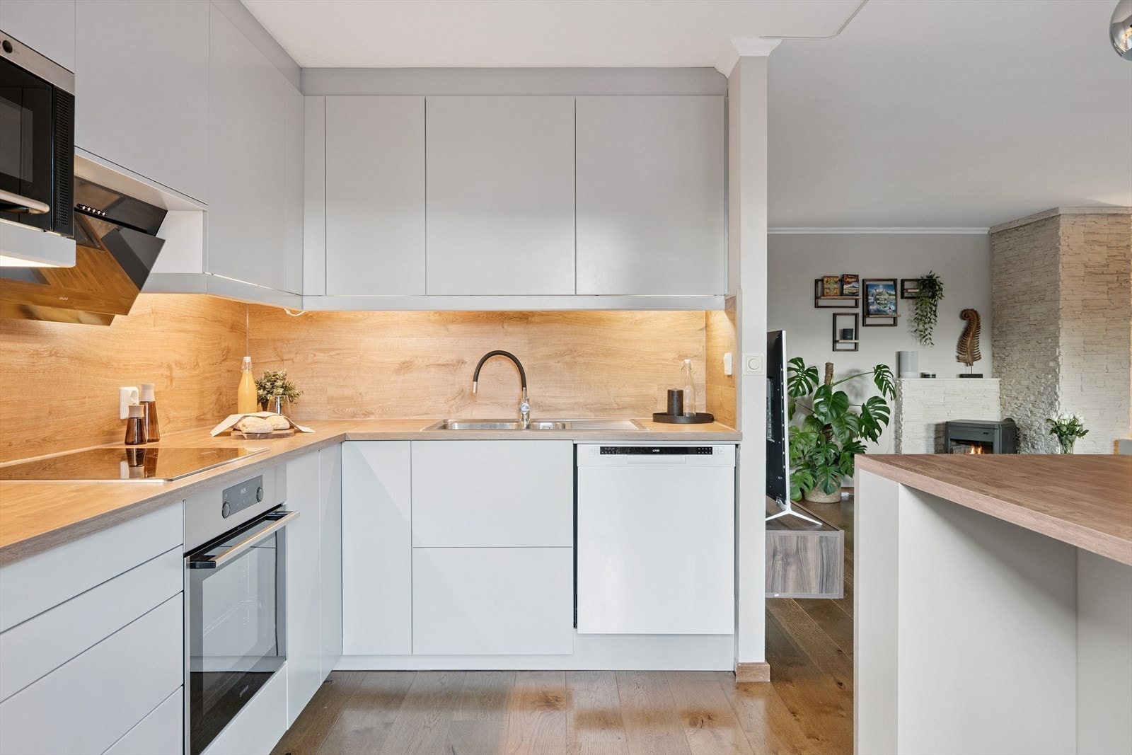 Kjøkkeninnredningen har slette fronter og laminatbenkeplate med integrert belysning. Galleribilde