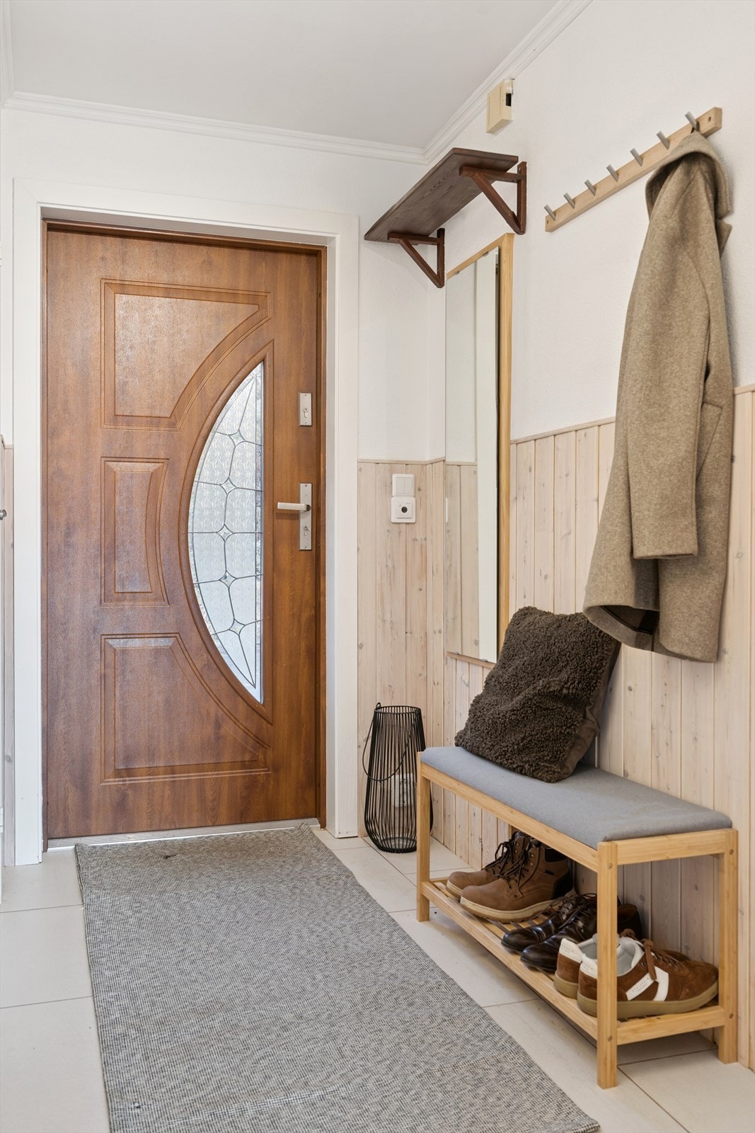 Inngangspartiet har en profilert ytterdør med glassfelt som slipper inn lys. Galleribilde