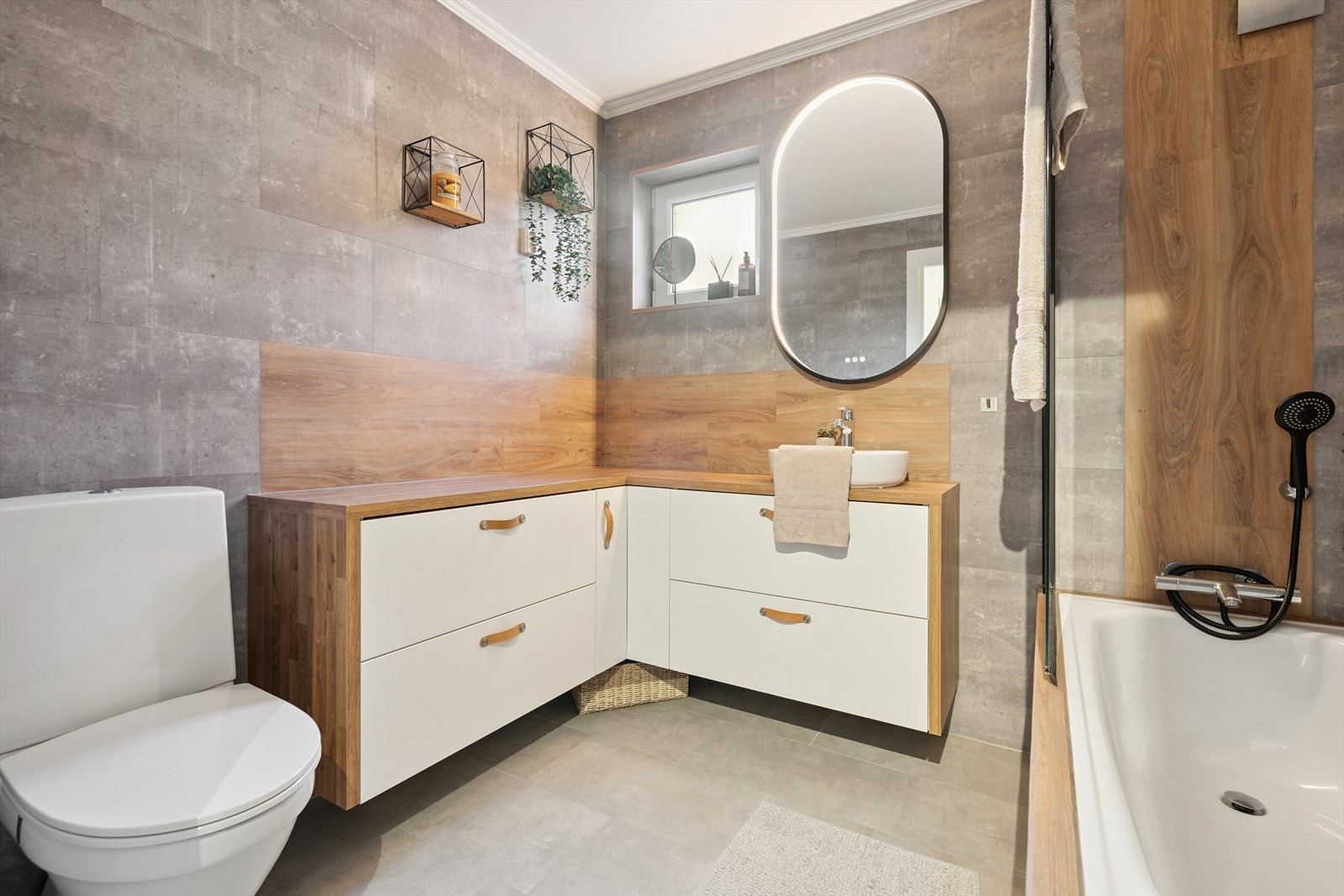 Romslig baderomsinnredning med håndvask, underskap og laminert benkeplate. Galleribilde