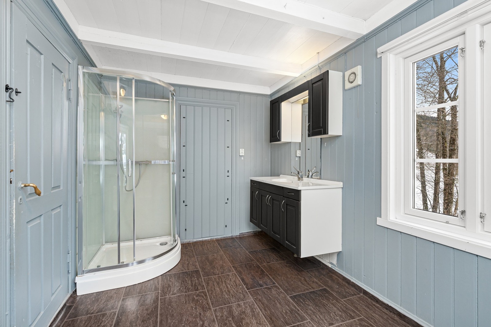 Dusjbad med kabinett, toalett og sort baderomsinnredning Galleribilde