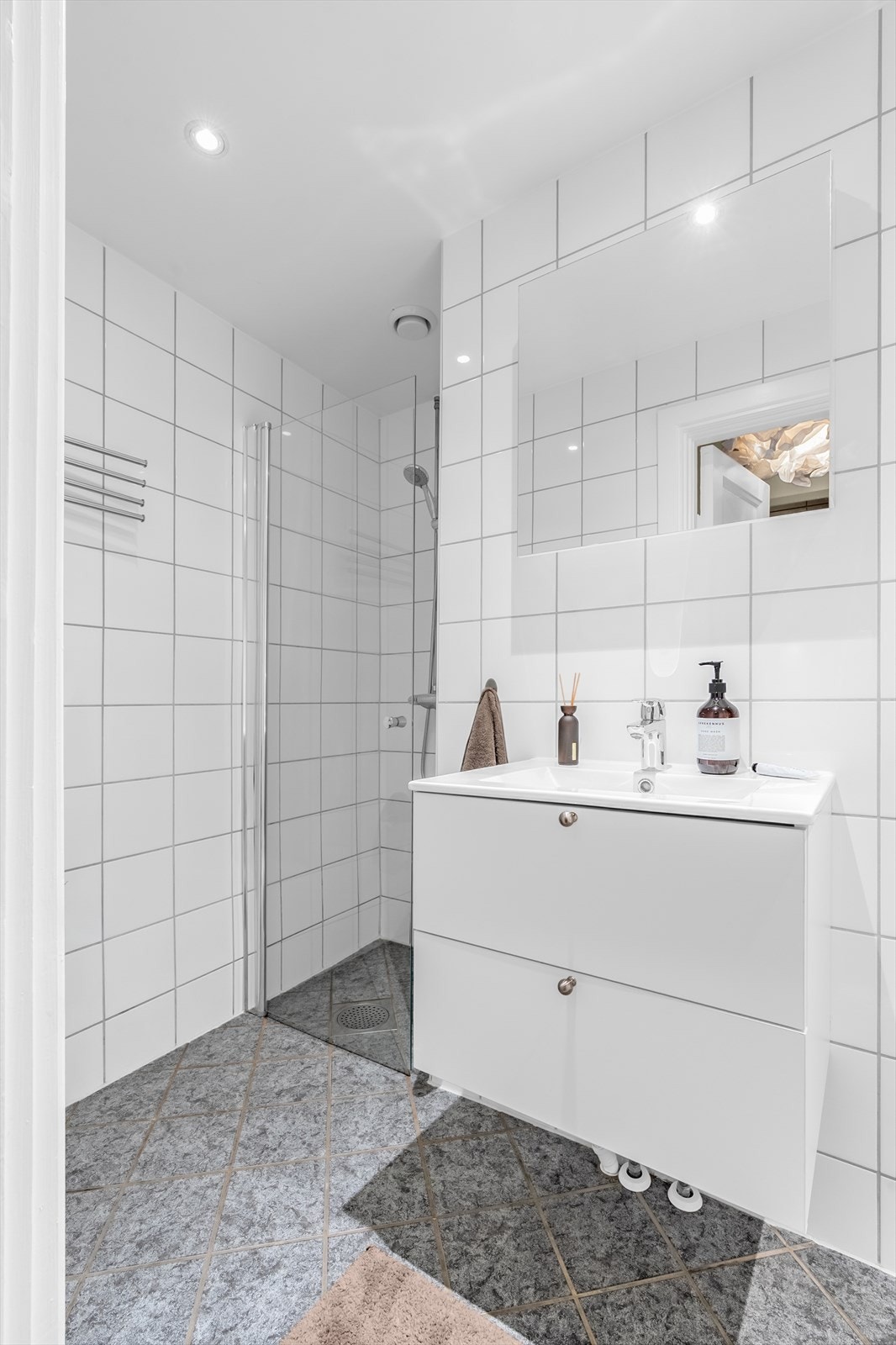 Badet er utstyrt med gulvmontert toalett og vegghengt servantinnredning med ovenpåliggende vask. Galleribilde