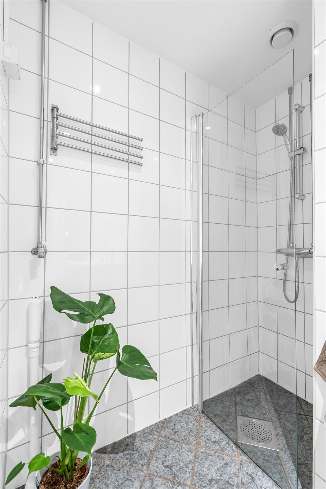 Videre er det dusjhjørne med glassdør og opplegg for vaskemaskin. Galleribilde