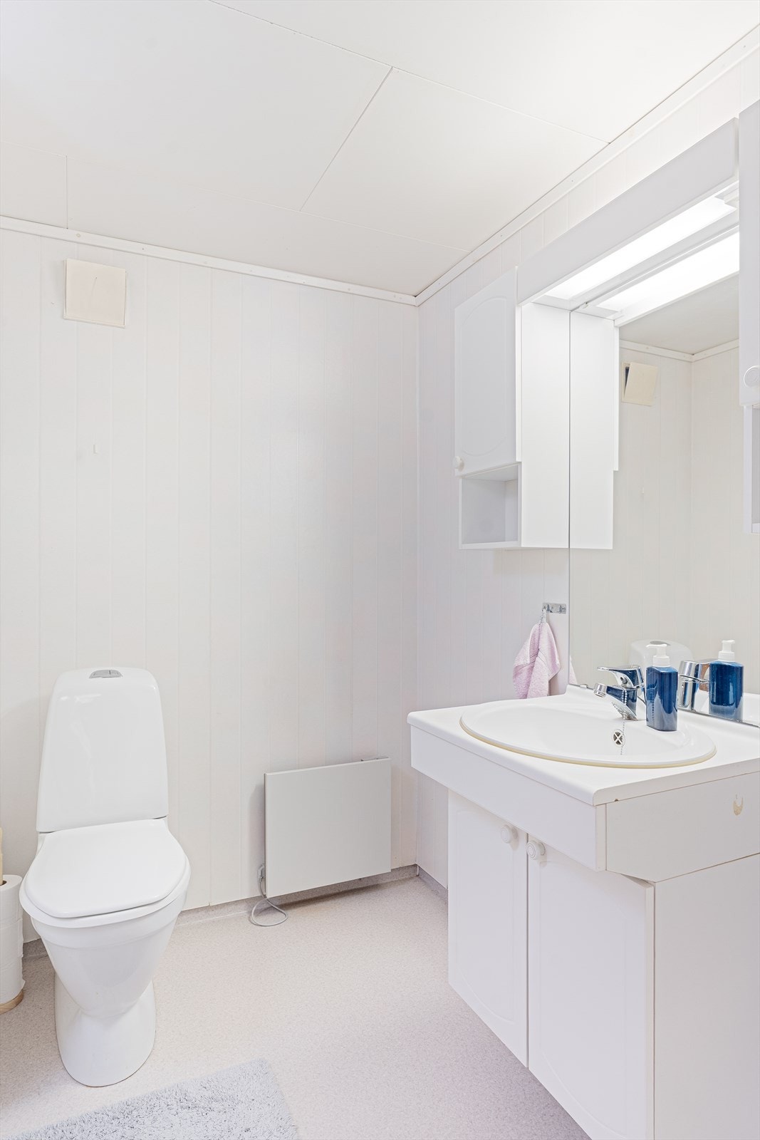 Badet i kjelleren har vinyltapet på veggene, malte plater i himlingen og belegg på gulvet Galleribilde