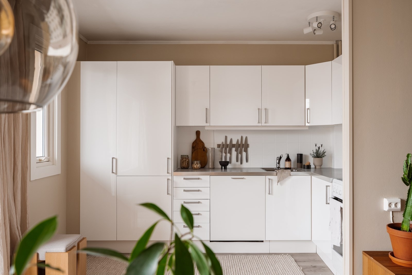 Åpen og sosial kjøkkenløsning som byr på godt med skap- og benkeplass Galleribilde