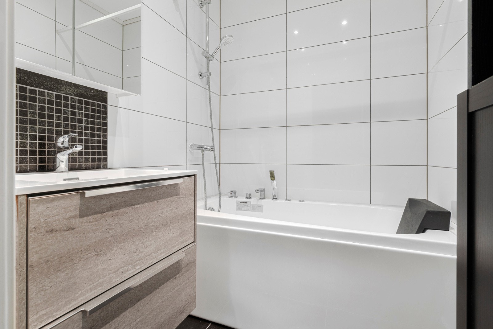 Badet er innredet med baderomsinnredning med tilhørende overskap og massasjebadekar. Galleribilde