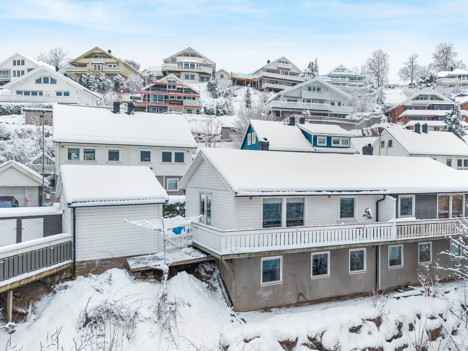 Lettstelt tomt med gangvei inn til boligen med belegningsstein og liten plenlagt hage med skjermet thujahekk mot gaten. Galleribilde