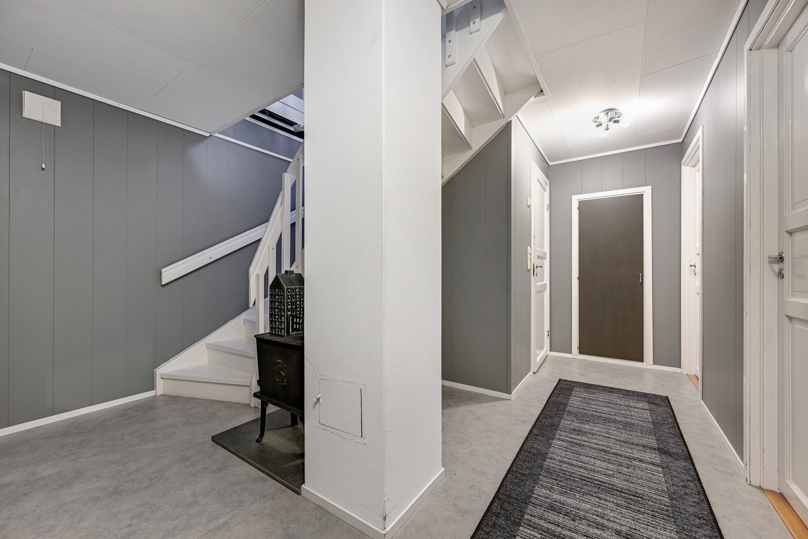 Trappegang/gang i u. etasjen med vedovn og varmekabler i gulv. Galleribilde