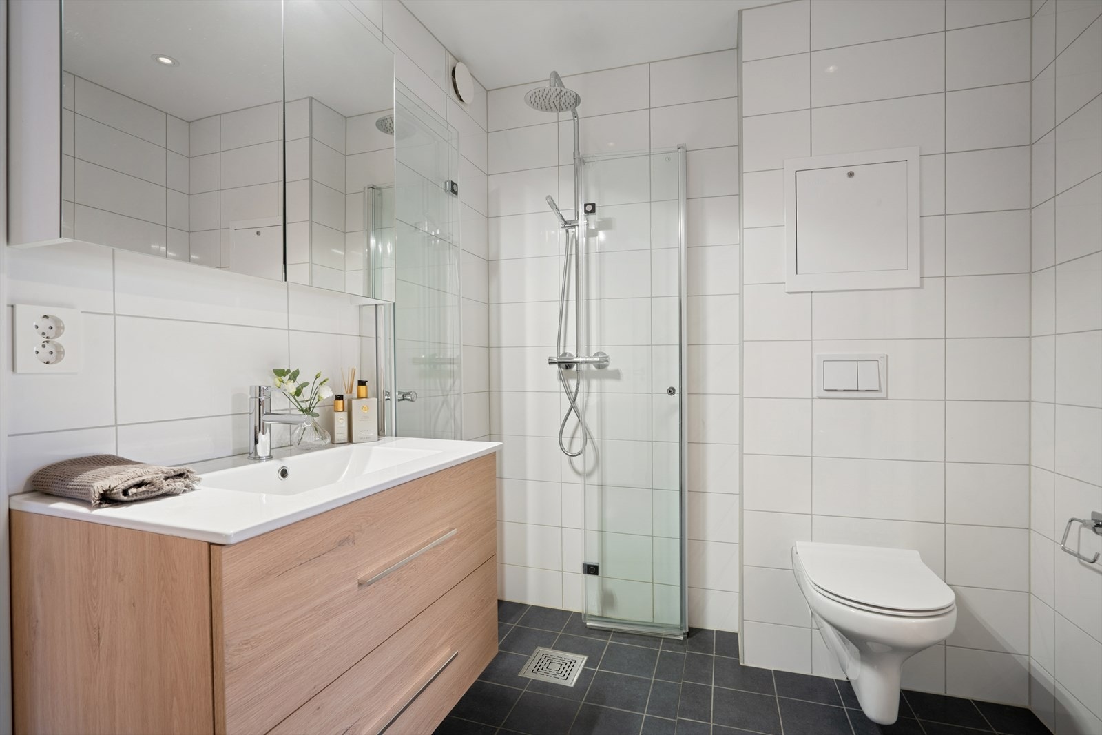 Baderommet ble pusset opp i regi av sameiet i 2022, og er innredet med tidløse fliser og stilig baderomsinnredning Galleribilde