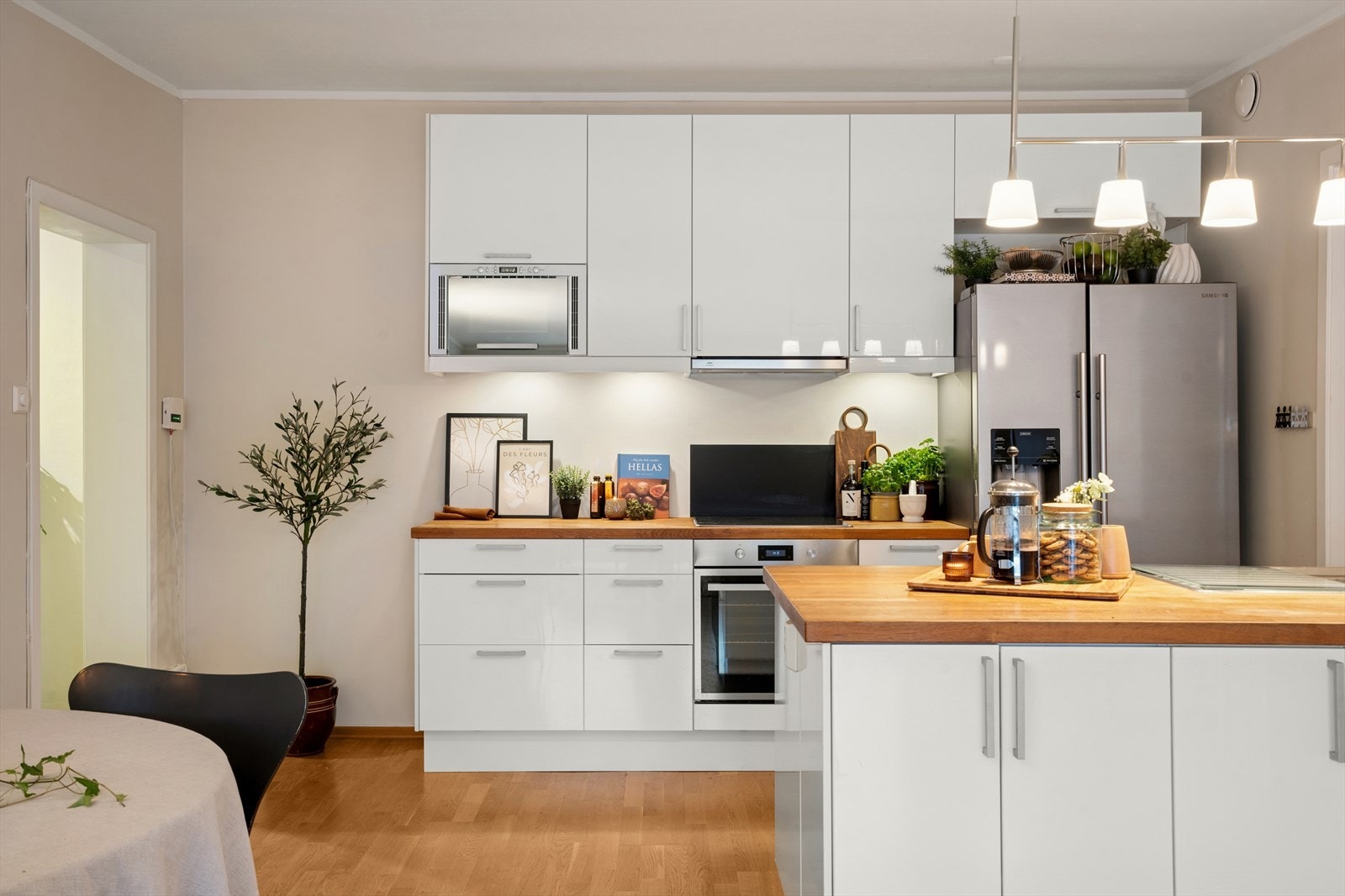 Innredningen består av glatte fronter, heltre benkeplate og integrerte hvitevarer som stekeovn, platetopp, mikrobølgeovn og oppvaskmaskin Galleribilde