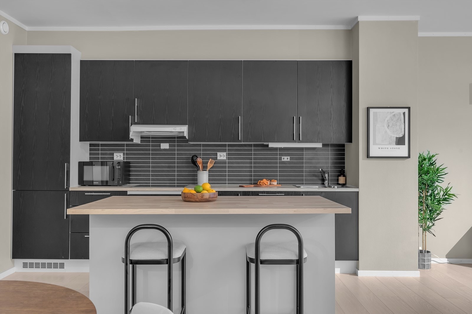 Tidløst kjøkken med kjøkkenøy. Integrerte hvitevarer på kjøkken og en praktisk kjøkkenøy. Galleribilde