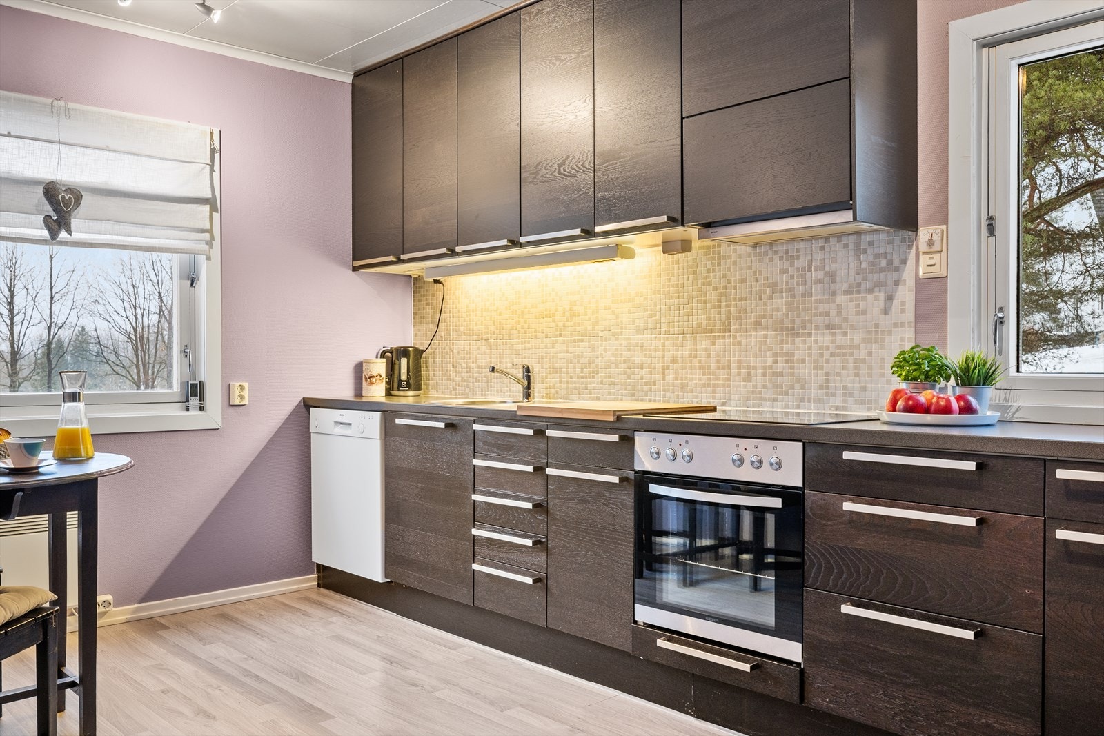 Kjøkkenet har innredning fra 2009 med glatte fronter og laminat benkeplate Galleribilde