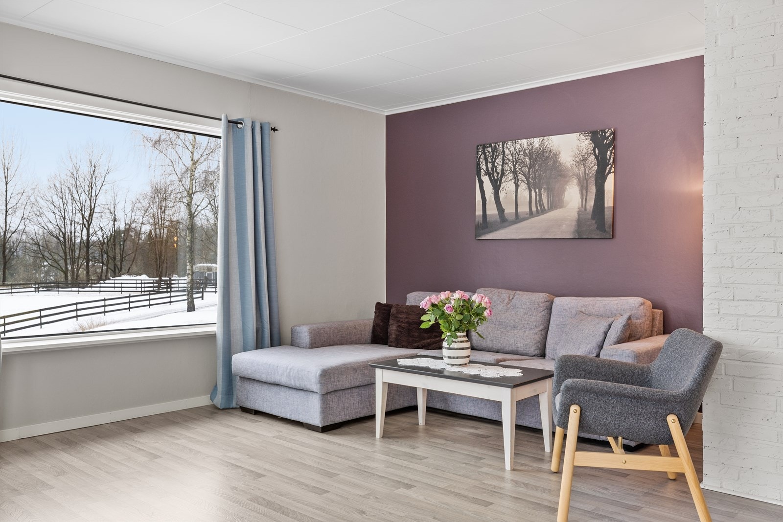 Stue er malt i en behagelig kombinasjon av beige toner med kontrastvegg i lilla. Eiendommen ligger usjenert til med landlig utsikt. Galleribilde