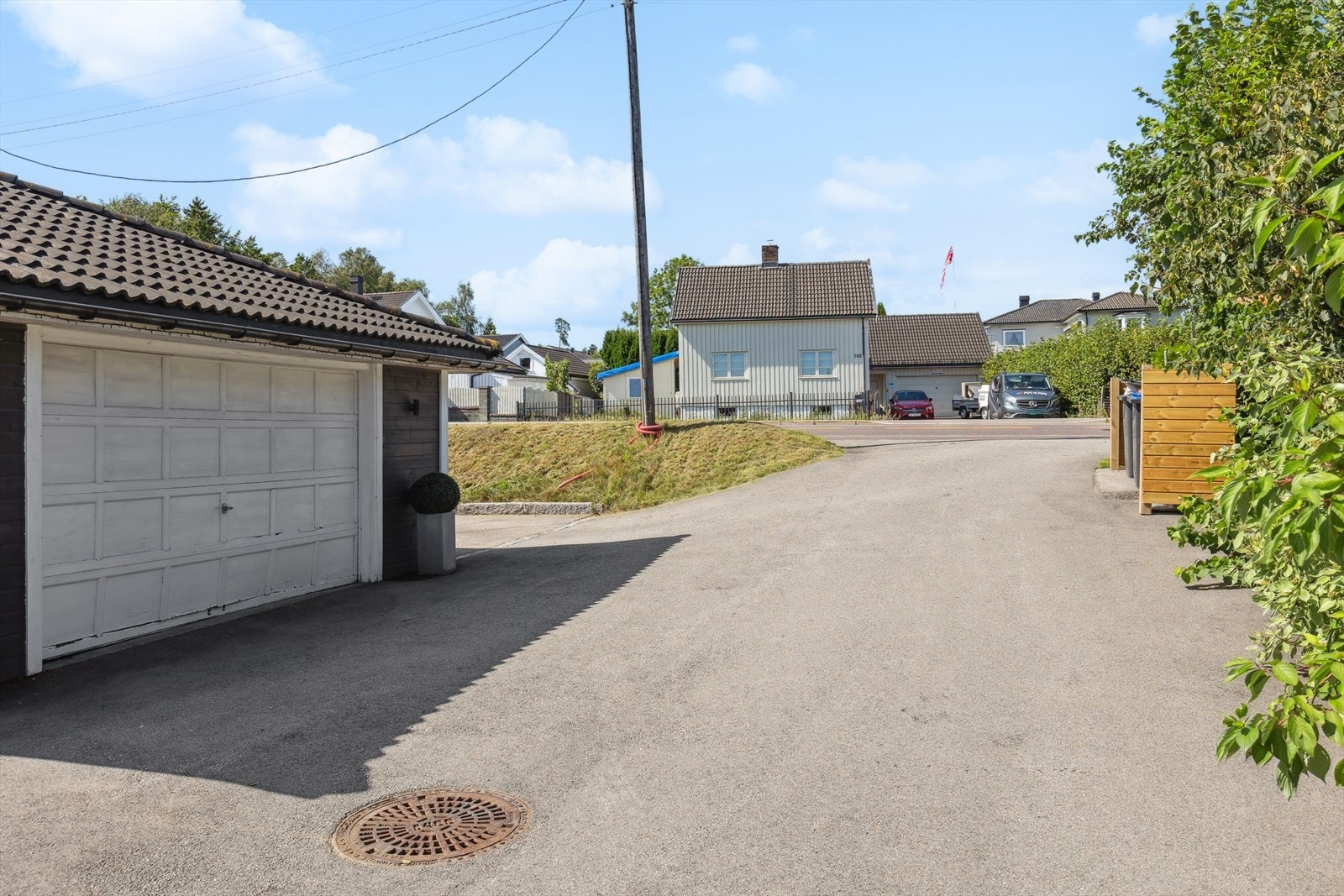 Romslig gårdsplass. "Garasjen" er innredet med oppholdsareal. Galleribilde
