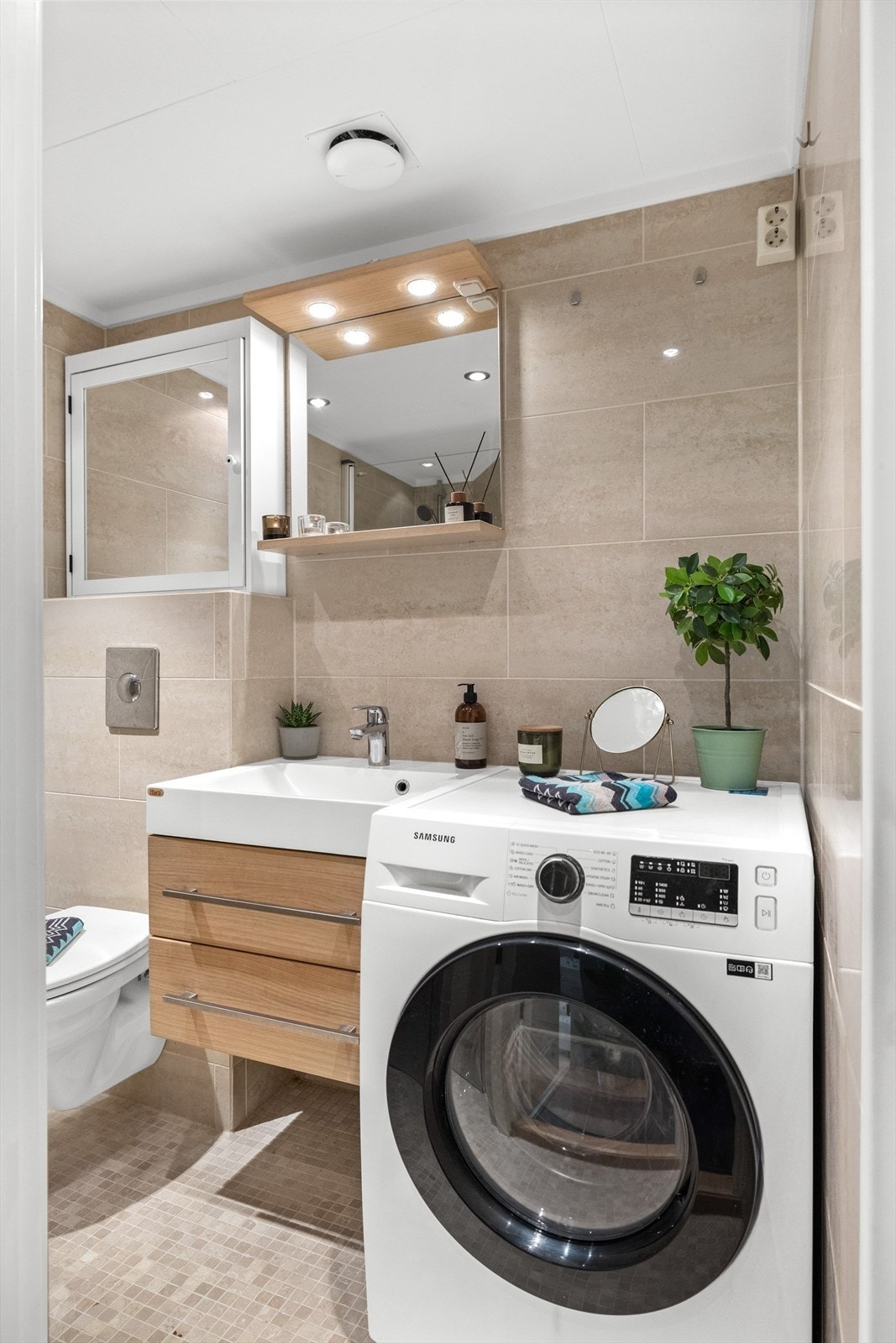 Pent flislagt baderom med malte plater i himling og innfelte downlights som gir god og behagelig belysning. Fliser på både vegger og gulv gir et helhetlig uttrykk, og elektrisk gulvvarme gir ekstra komfort. Galleribilde