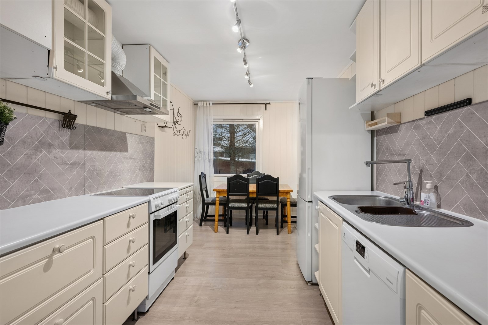 Kjøkken av romslig utførelse med lyse overflater. Godt med lagringsplass i over- og underskap. Galleribilde