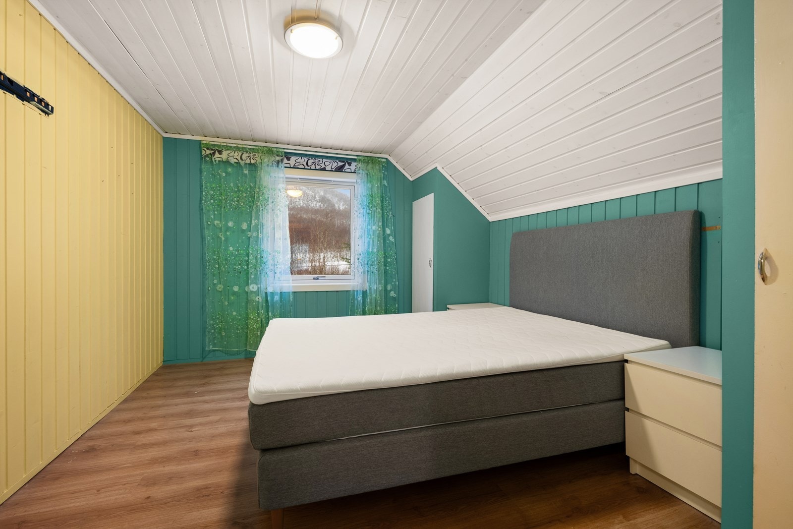 Romslig soverom med skråtak og god plass til dobbeltseng og nattbord. Plassbygget garderobeskap. Galleribilde