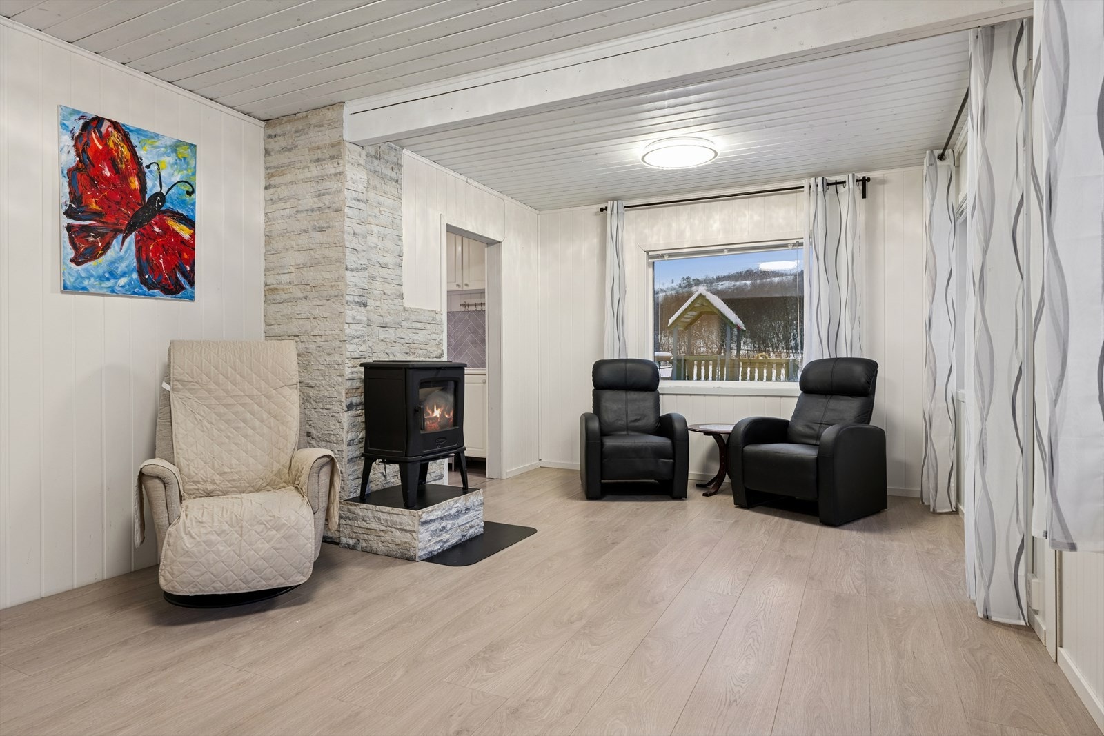 Stue med lyse og nyere overflater, samt noen nye vinduer og verandadør. Galleribilde