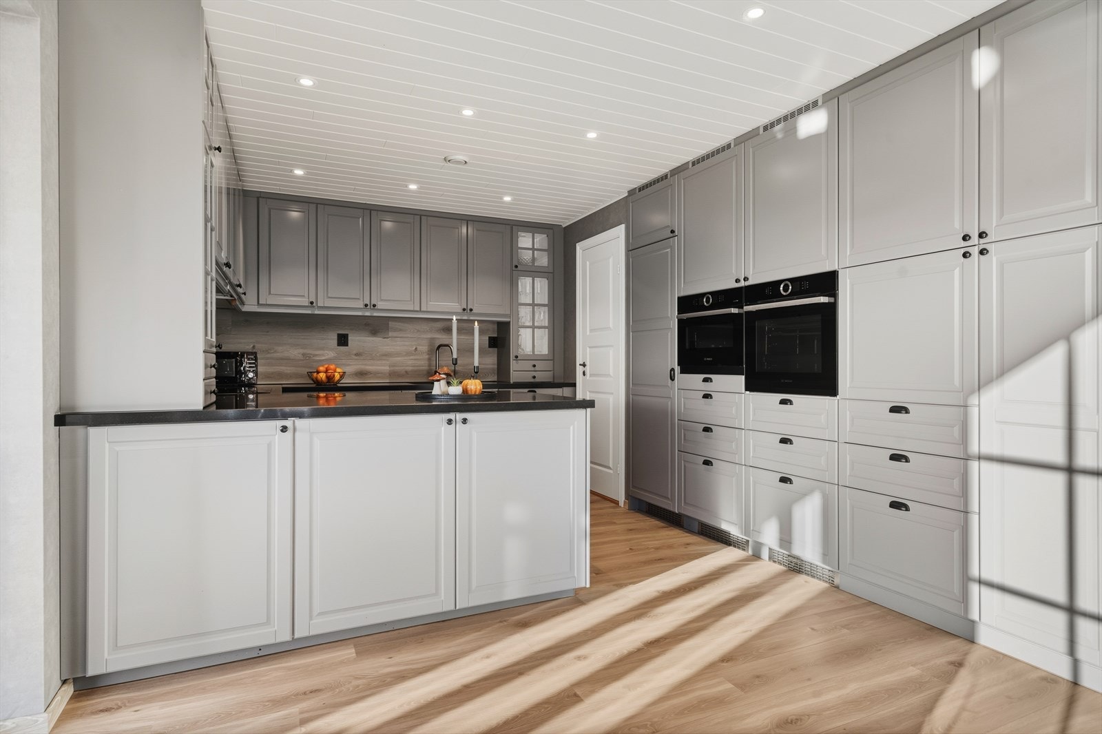 Lekkert moderne kjøkken med integrerte hvitevarer og rikelig med skap- og benkeplass. Galleribilde