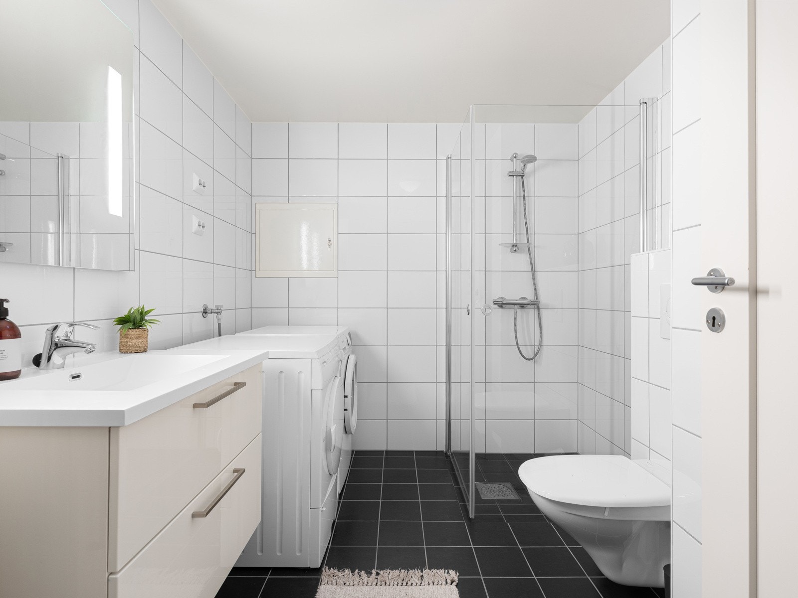 Badet er utstyrt med servant, høyskap, toalett og dusj. I tillegg har man opplegg for vaskemaskin. Galleribilde