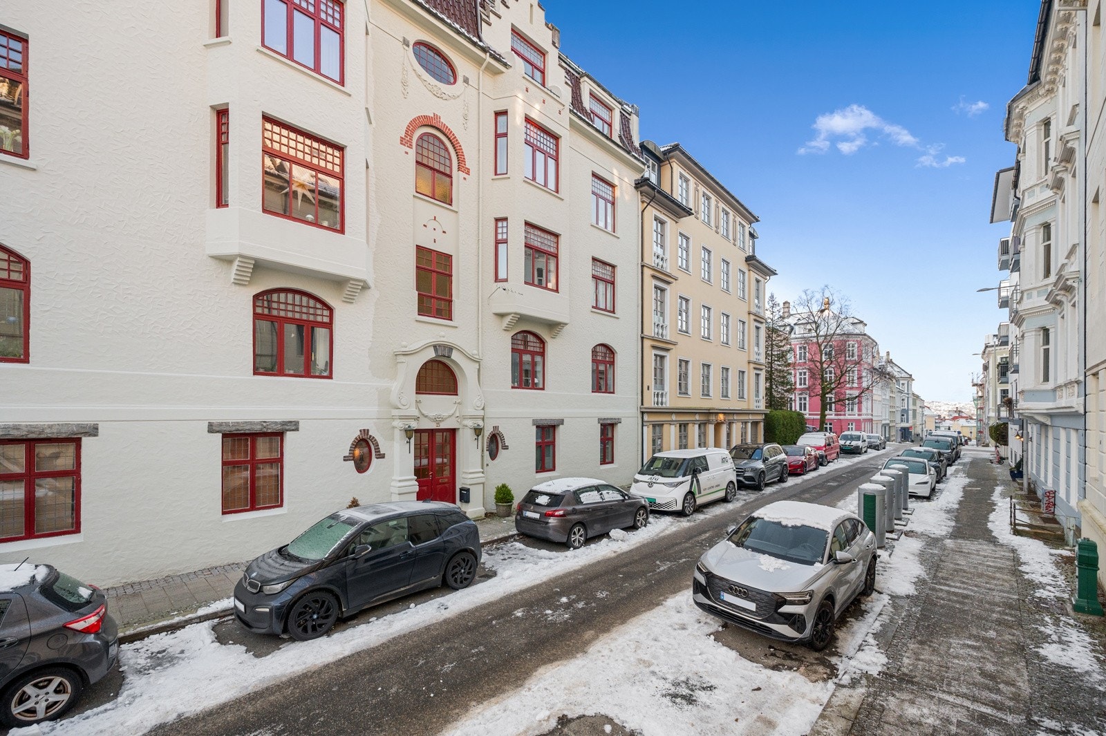 Ved inngangen til Rosenbergsgaten 25 møtes man av byggets store røde inngangsdør og gjennomarbeidede fasadedetaljer i nyklassisistisk stil. Galleribilde