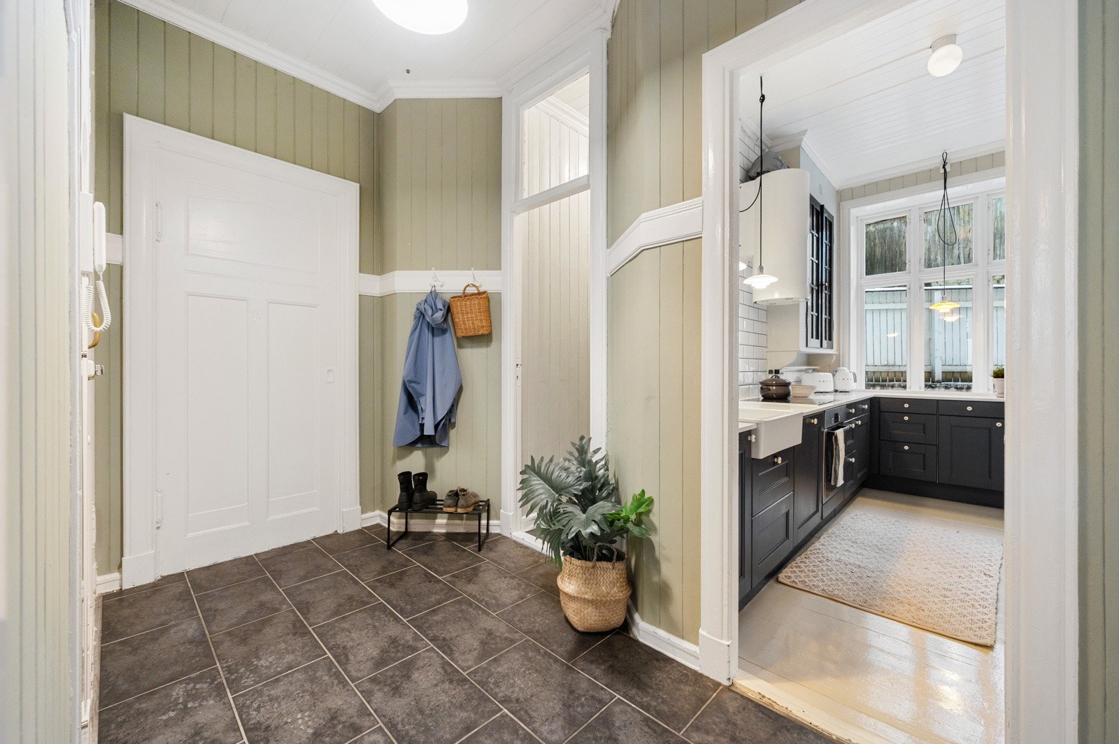 Kjøkkenet ligger i eget rom og har en praktisk L-formet innredning med skap langs én vegg og under vindu, noe som gir gode arbeidsflater. Galleribilde