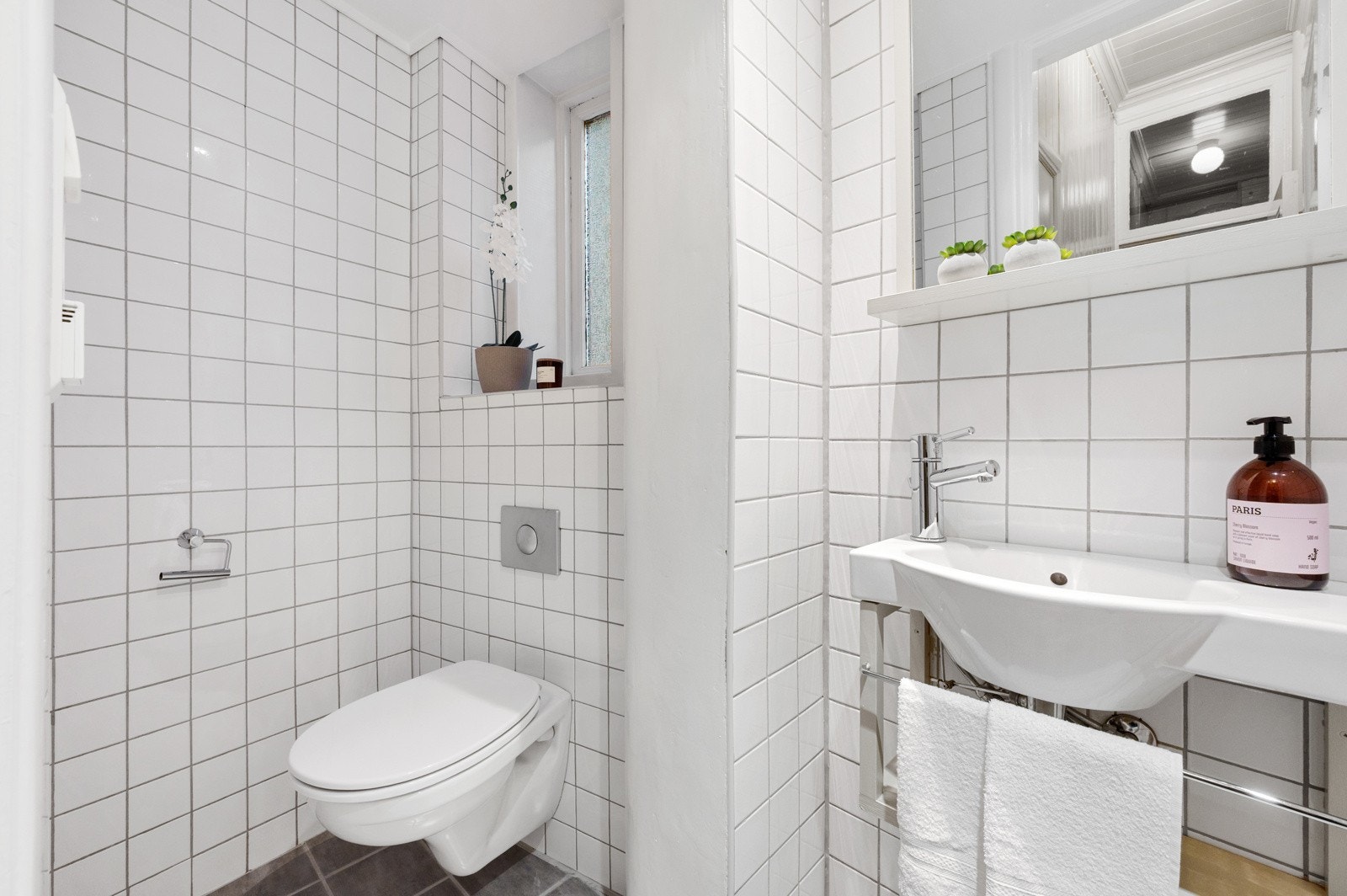 Toalettet ligger praktisk plassert i eget rom. Rommet inneholder vegghengt toalett, servant, varmekabler i gulv og belysning i tak, og fremstår som et praktisk supplement til badet. Galleribilde