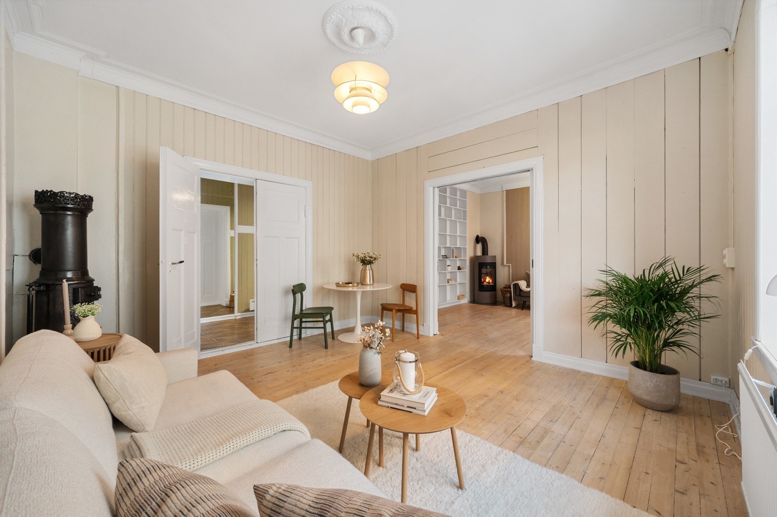 Videre inn åpner leiligheten seg opp med spisestue og stue, adskilt av doble dører. Galleribilde